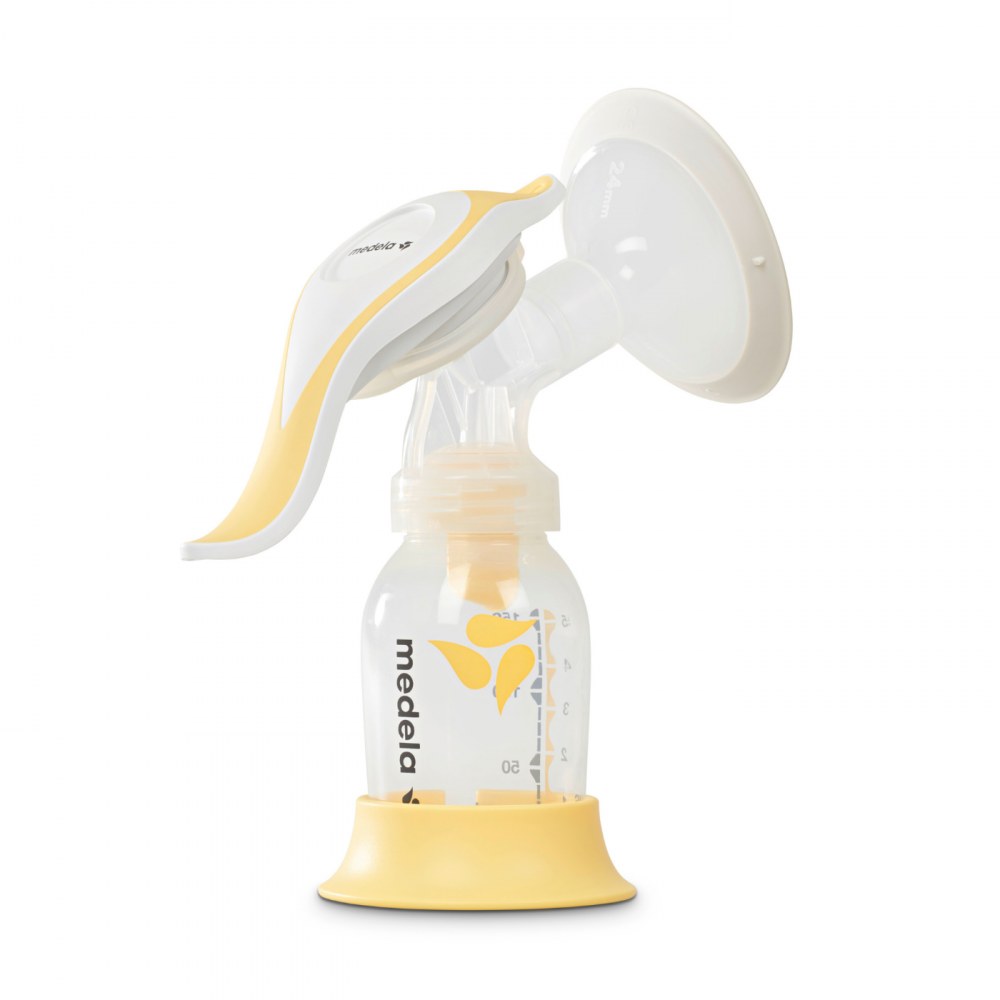 Medela Harmony manual breast pump with handle, shield and bottle on its stand